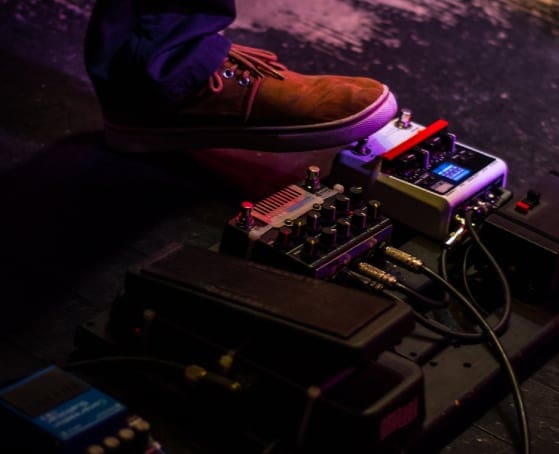 Image of a pedalboard beign used by a guitarist on stage
